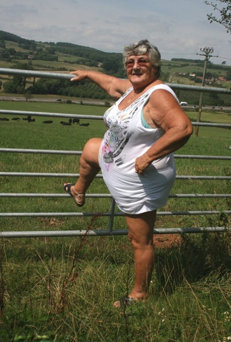 Old British woman Grandma Libby exposes herself next to a field of cattle