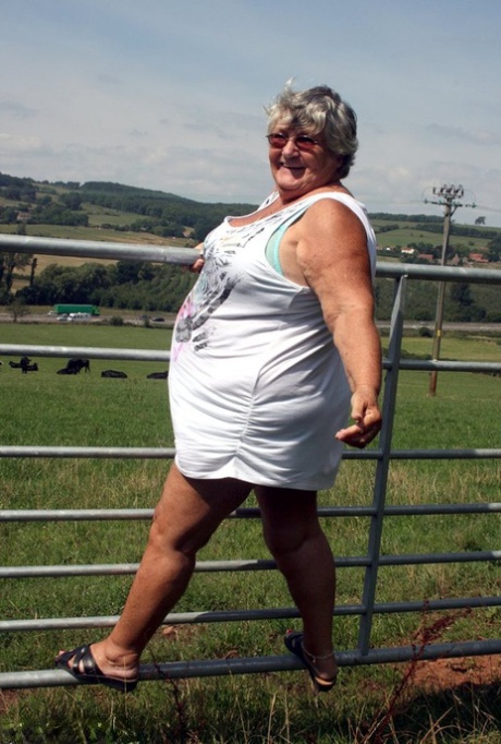 Old British woman Grandma Libby exposes herself next to a field of cattle