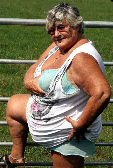 Old British woman Grandma Libby exposes herself next to a field of cattle