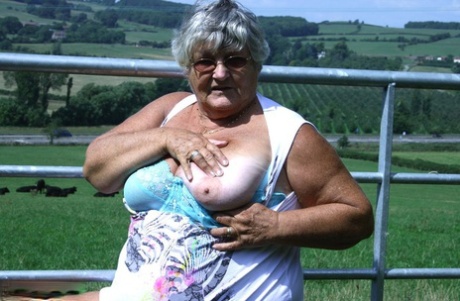 Old British woman Grandma Libby exposes herself next to a field of cattle
