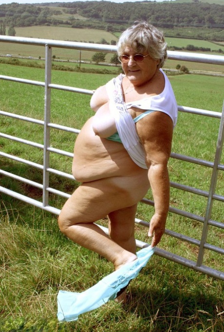 Old British woman Grandma Libby exposes herself next to a field of cattle