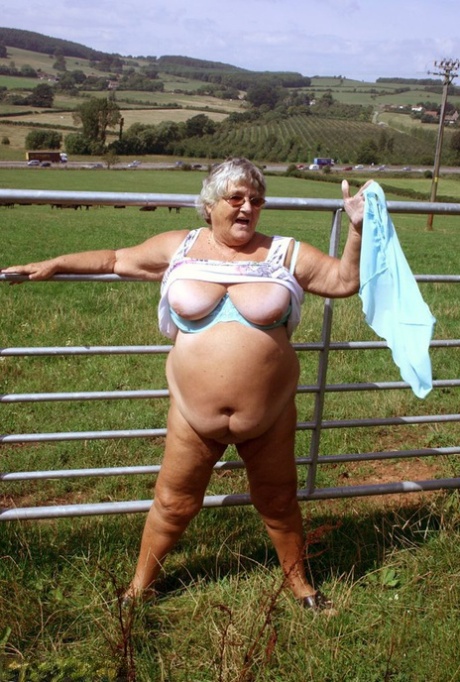 Old British woman Grandma Libby exposes herself next to a field of cattle