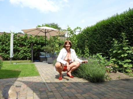 Old woman Kat Kitty gets naked on outdoor sofa while painting her toenails