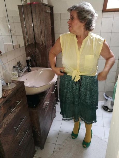 Old woman Caro releases her hairy vagina from yellow pantyhose on her bed