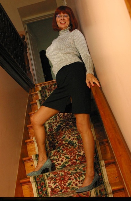 Older redhead Abigail Fraser exposes her tits and pink cunt on a staircase