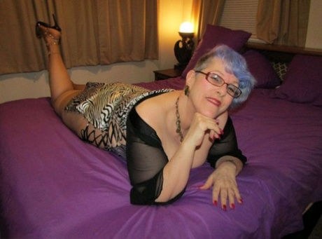 Old woman Bunny Gram shows her hose covered pussy on a bed in pointy shoes