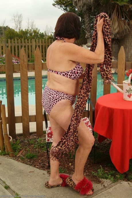 Dark-haired granny Mona strips poolside and shows her hairy holes
